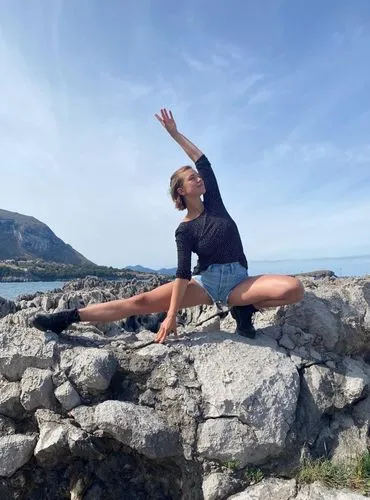 Melina Schoedon in einer Yogahaltung auf einem Felsen am Meer